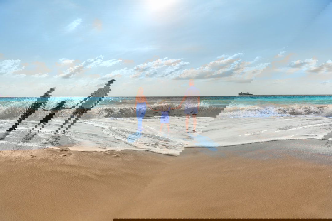 Reisegutschein verschenken: Familie am Strand als Symbol für gemeinsame Auszeit