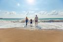 Reisegutschein verschenken: Familie am Strand als Symbol für gemeinsame Auszeit