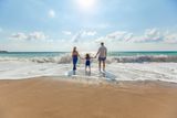 Reisegutschein verschenken: Familie am Strand als Symbol für gemeinsame Auszeit